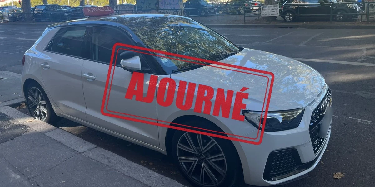 Voiture d'auto-école garée en ville, avec un tampon rouge "Ajourné"